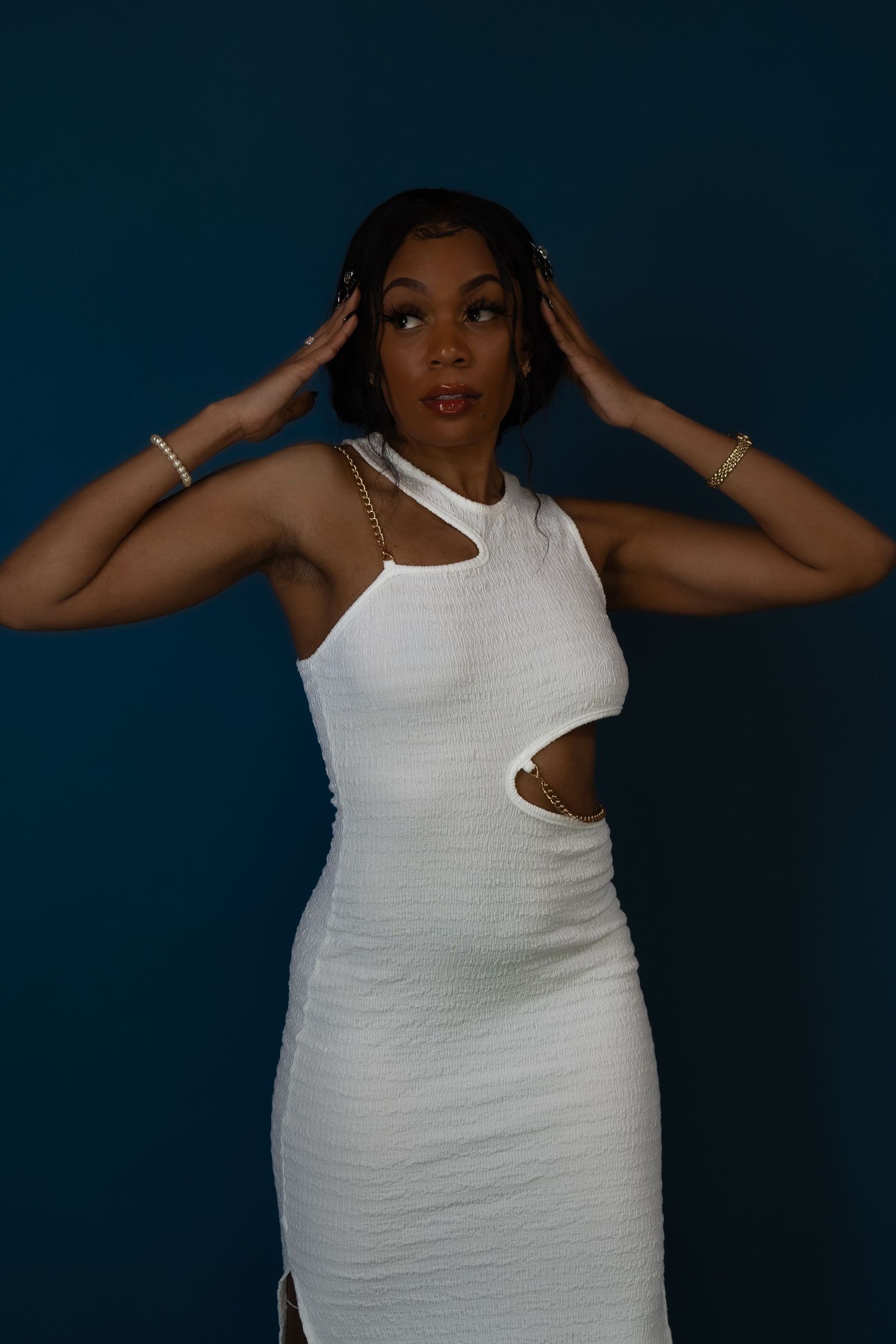 Modern fashion photo in white cutout dress against blue background.