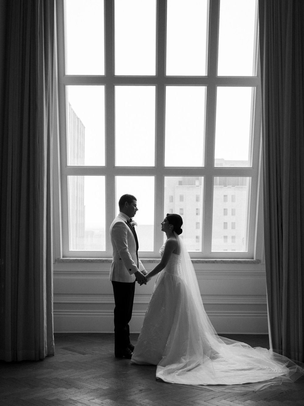 A series of black and white wedding photographs showing silhouettes against bright windows in an elegant room.