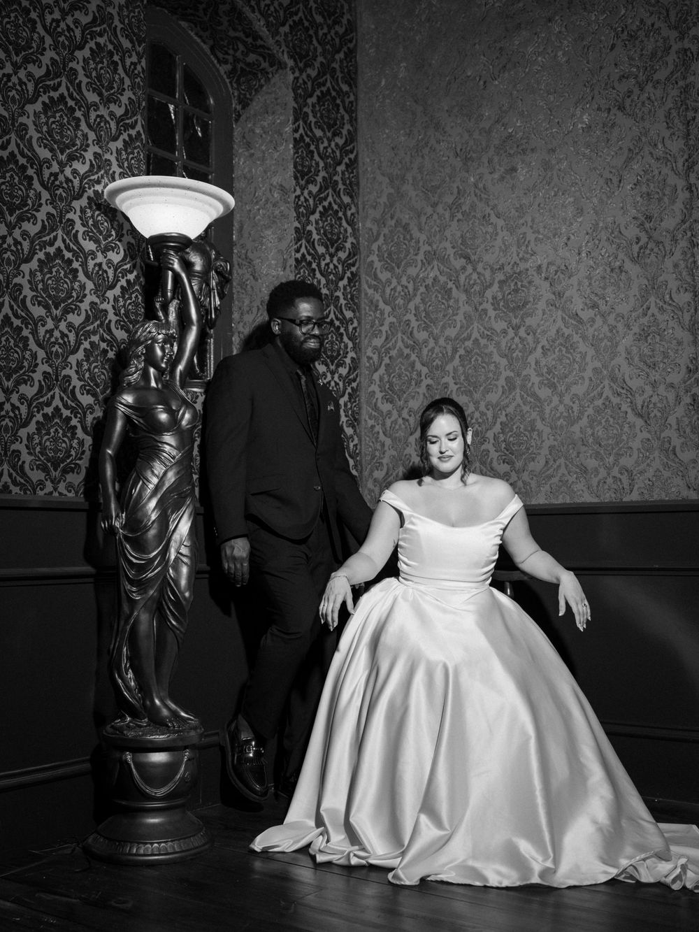A series of black and white wedding photos showing a person in a white dress seated against an ornate damask wallpaper.