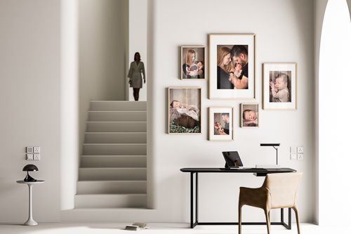 Modern minimalist interior with white walls, framed photos, and sleek furniture creating a clean gallery-like aesthetic.