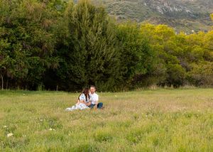 Panoramic view of couple relaxing in mountain meadow landscape.