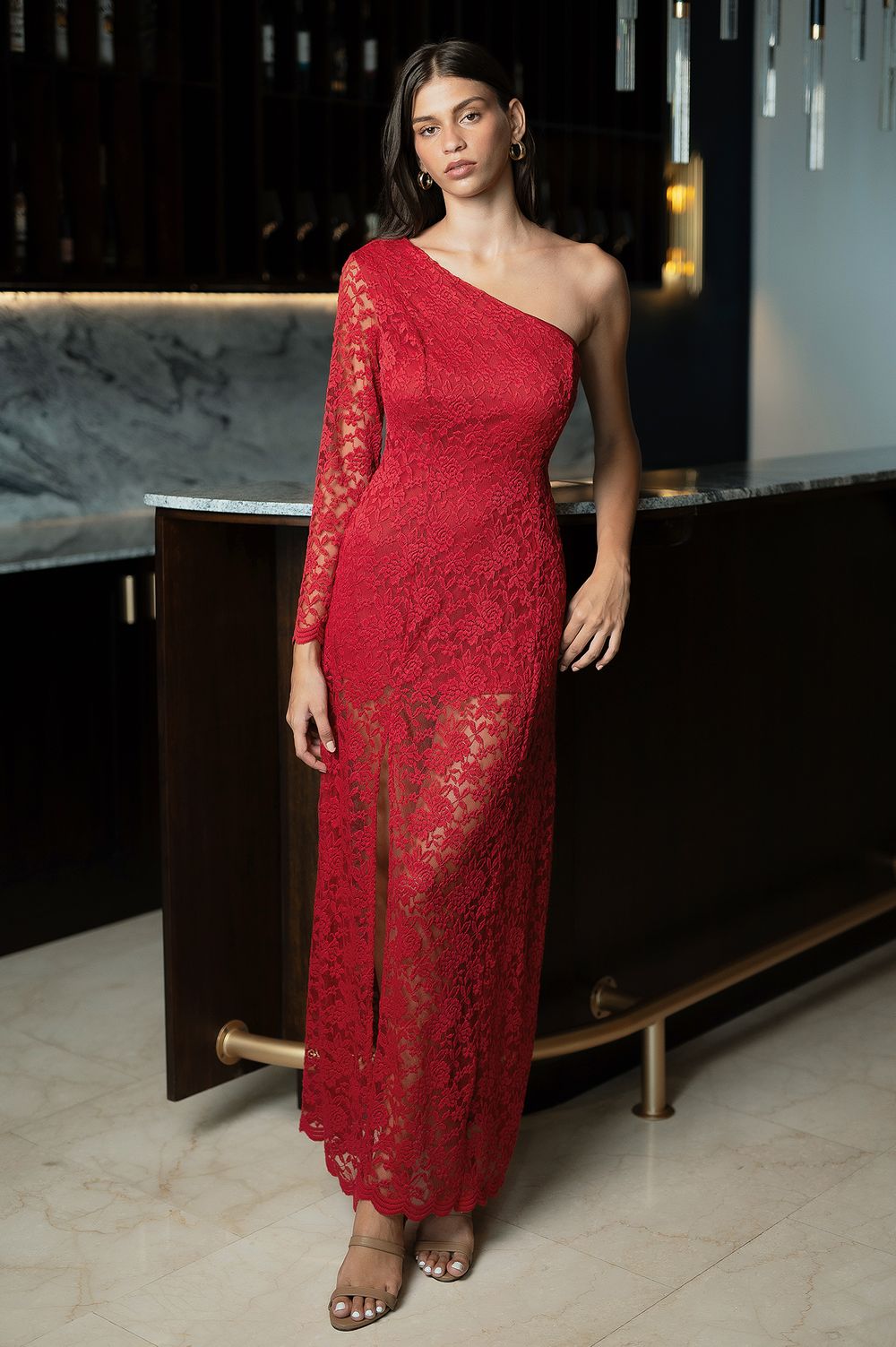 Red lace one-shoulder evening gown with long sleeve and floor-length silhouette.
