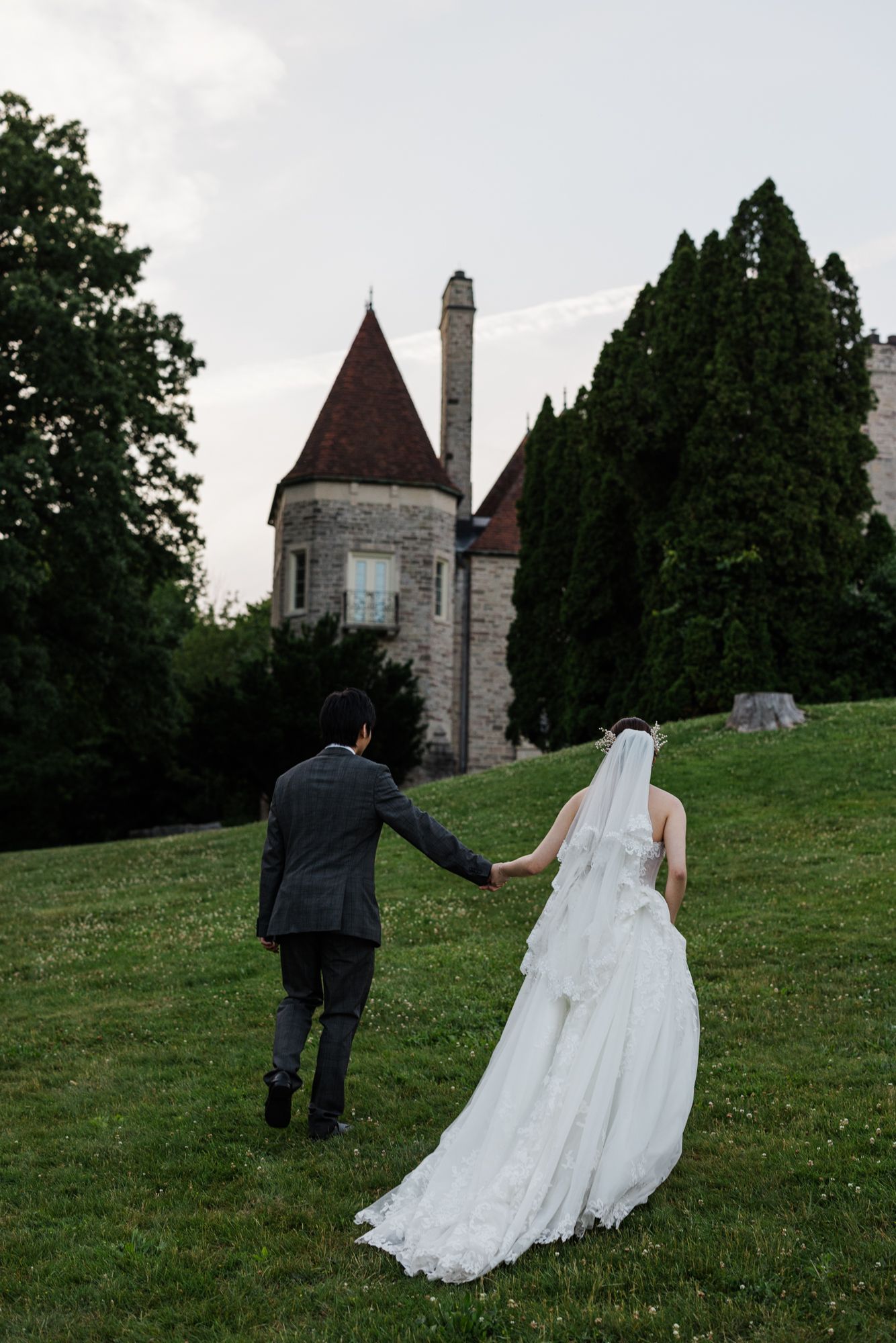 portrait of bride and groom holding hands and walking away from camera in Eaton Hall wedding venue.