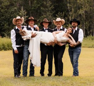 Five groomsmen in cowboy hats carry the bride in a white wedding gown on a green lawn.