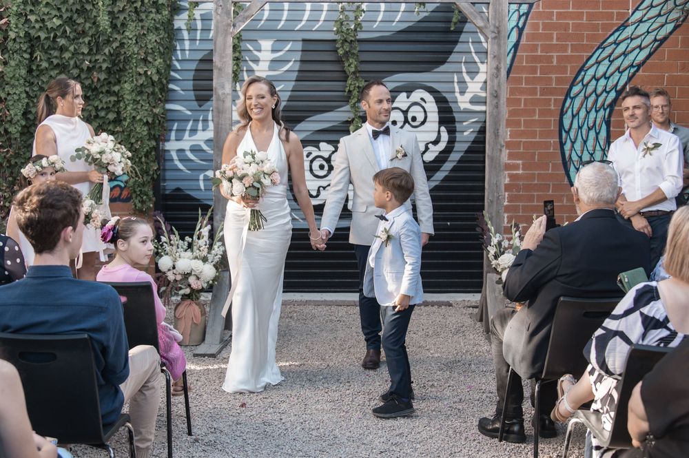 Wedding celebration in a garden setting with guests seated watching a special moment unfold.