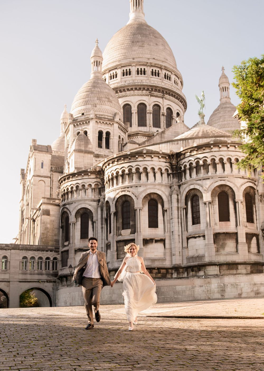 Bride and groom running down the street during destination wedding in Paris, France.