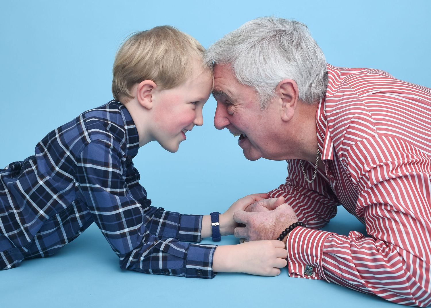 An older man and a young boy lying on the floor, enjoying a moment together in Abigail's Studio, High Wycombe.