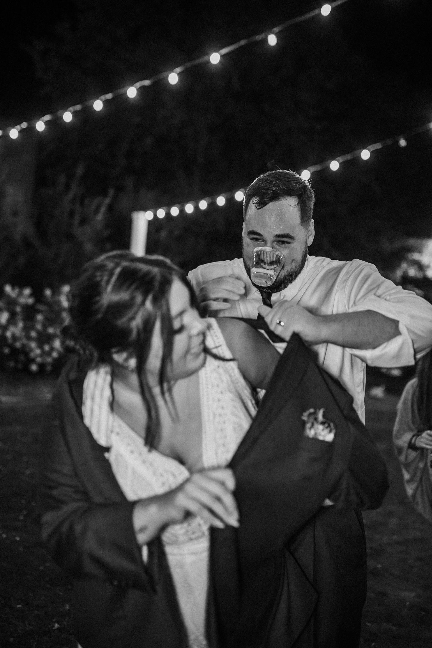 groom helping bride into his coat on a chilly wedding reception evening in newport news, virginia