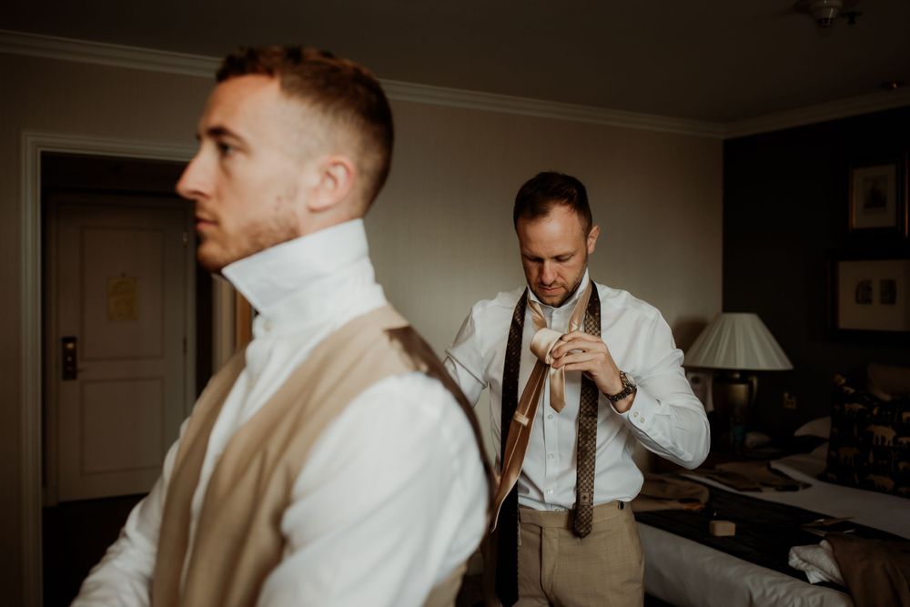 Two men in formal attire preparing for London wedding ceremony