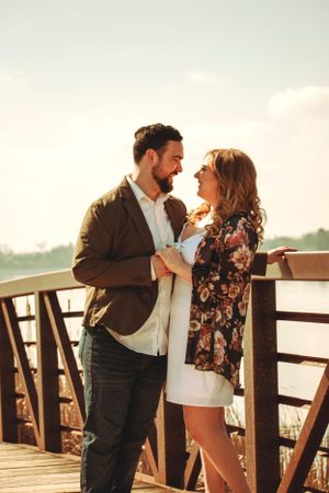 Couple sharing a joyful moment on a wooden deck overlooking a scenic view.