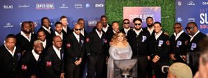 Large group of formally dressed attendees pose together at the Super Bowl Soulful Celebration event.