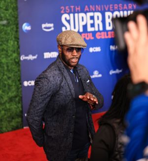 An attendee in a tweed cap poses for photographers at the Super Bowl Soulful Celebration.