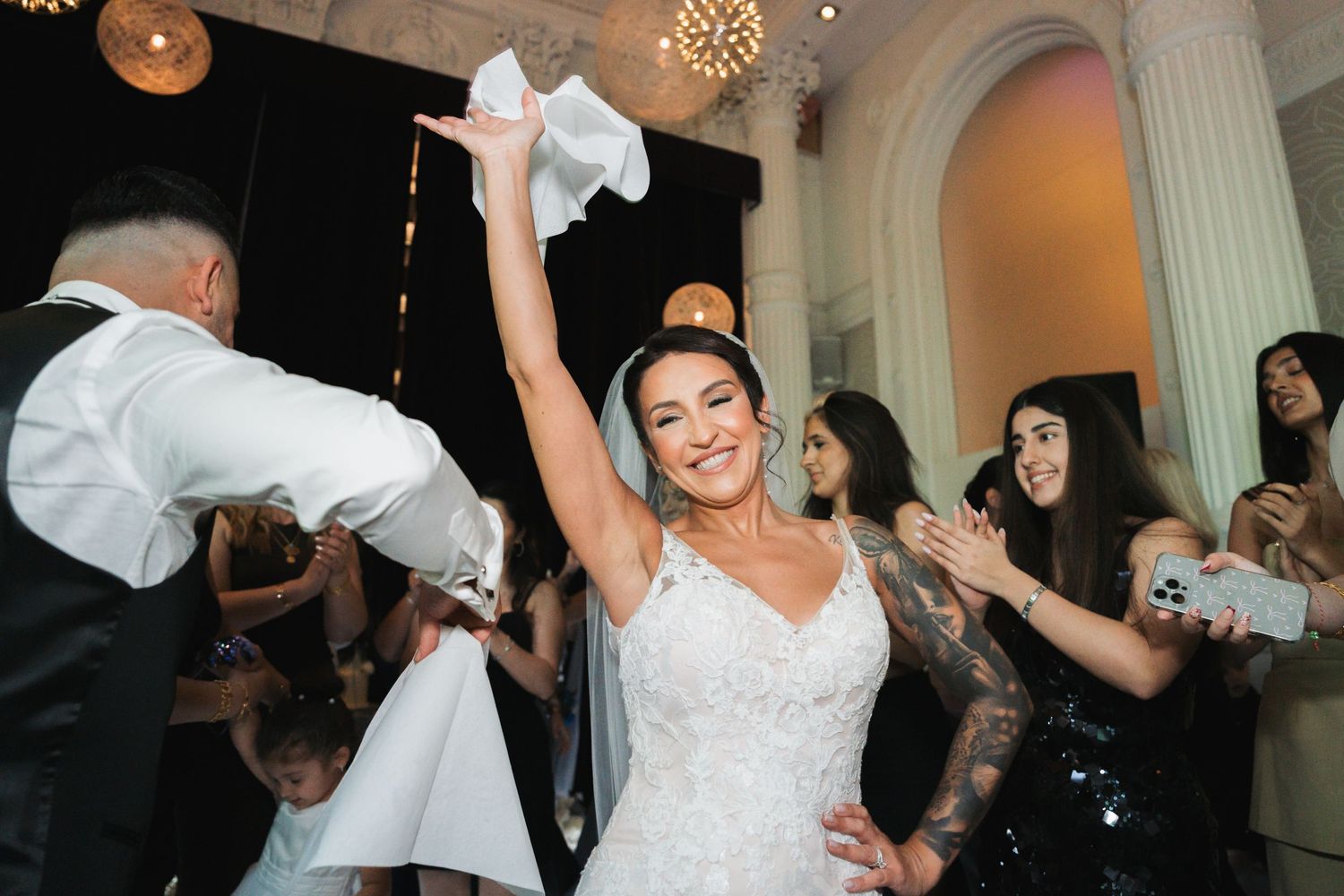 Joyful celebration on the dance floor with napkin waving and festive atmosphere.