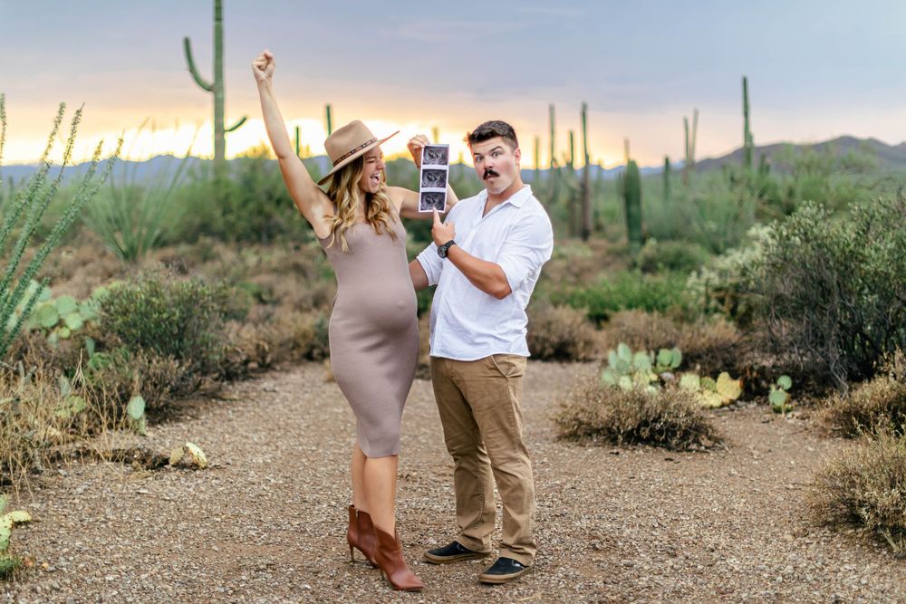 A couple embraces during a romantic sunset photoshoot in the Arizona desert surrounded by saguaro cacti.