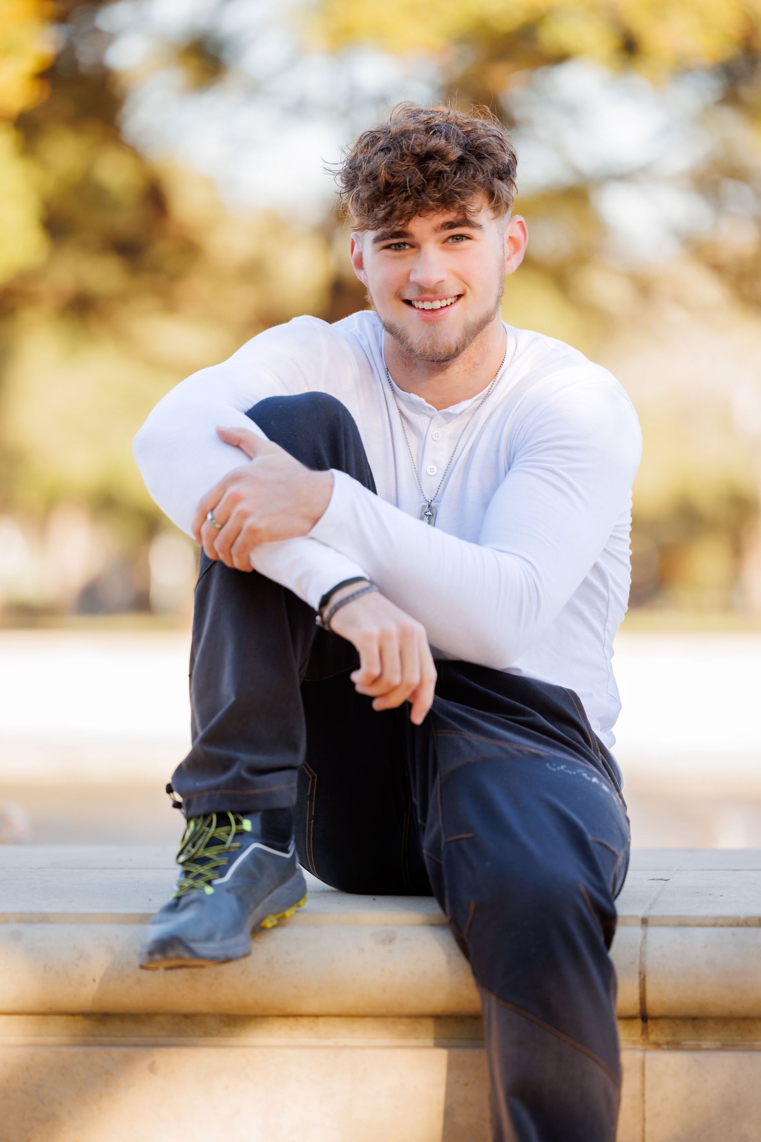 Casual portrait in autumn setting with golden bokeh background.
