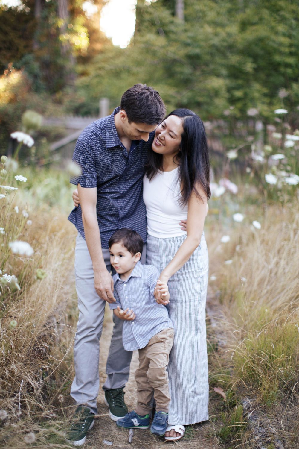 Seattle lifestyle photography: A mother and father stand close together with their son in between them at Washington Park Arboretum Seattle