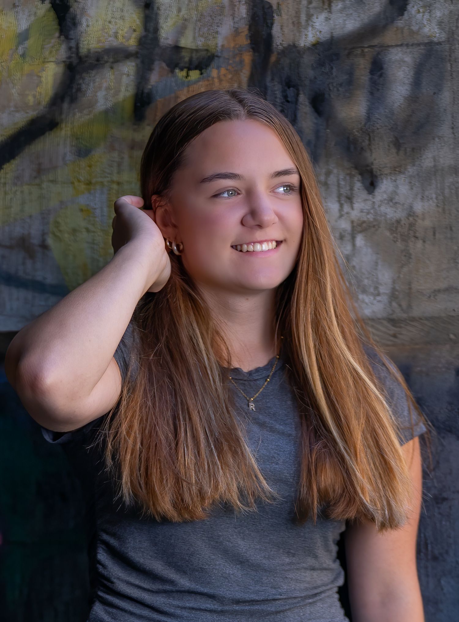 Portrait session with person in gray shirt against textured wall.