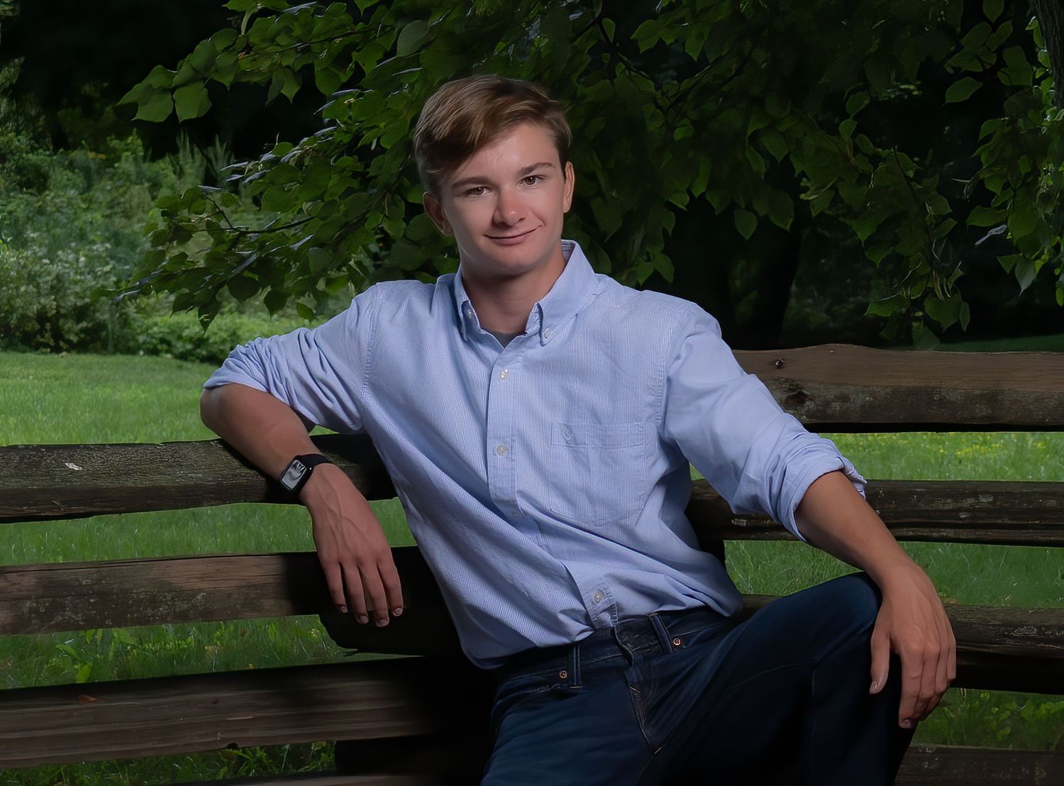 Outdoor portrait session on wooden bench with scenic nature background.