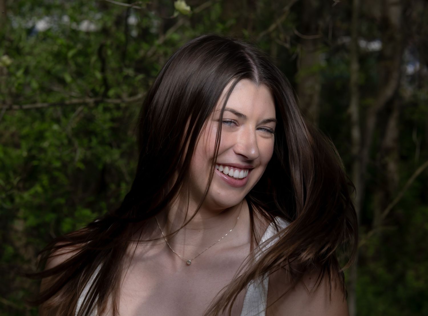 Portrait session outdoors with natural lighting and foliage background.