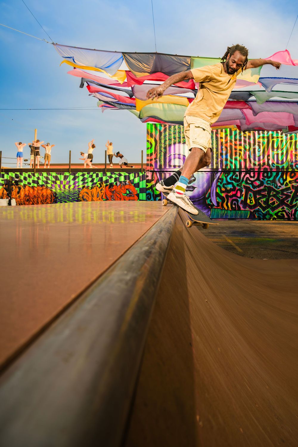 Sequence of action shots showing a skateboarder performing a flip trick against a colorful graffiti wall background.