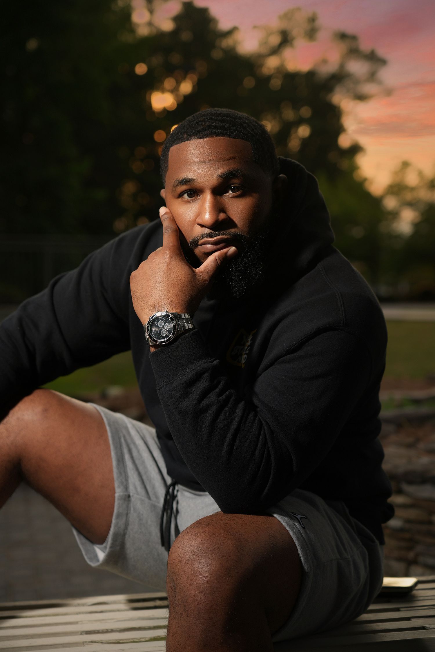Outdoor portrait at sunset featuring casual athletic wear and luxury watch.