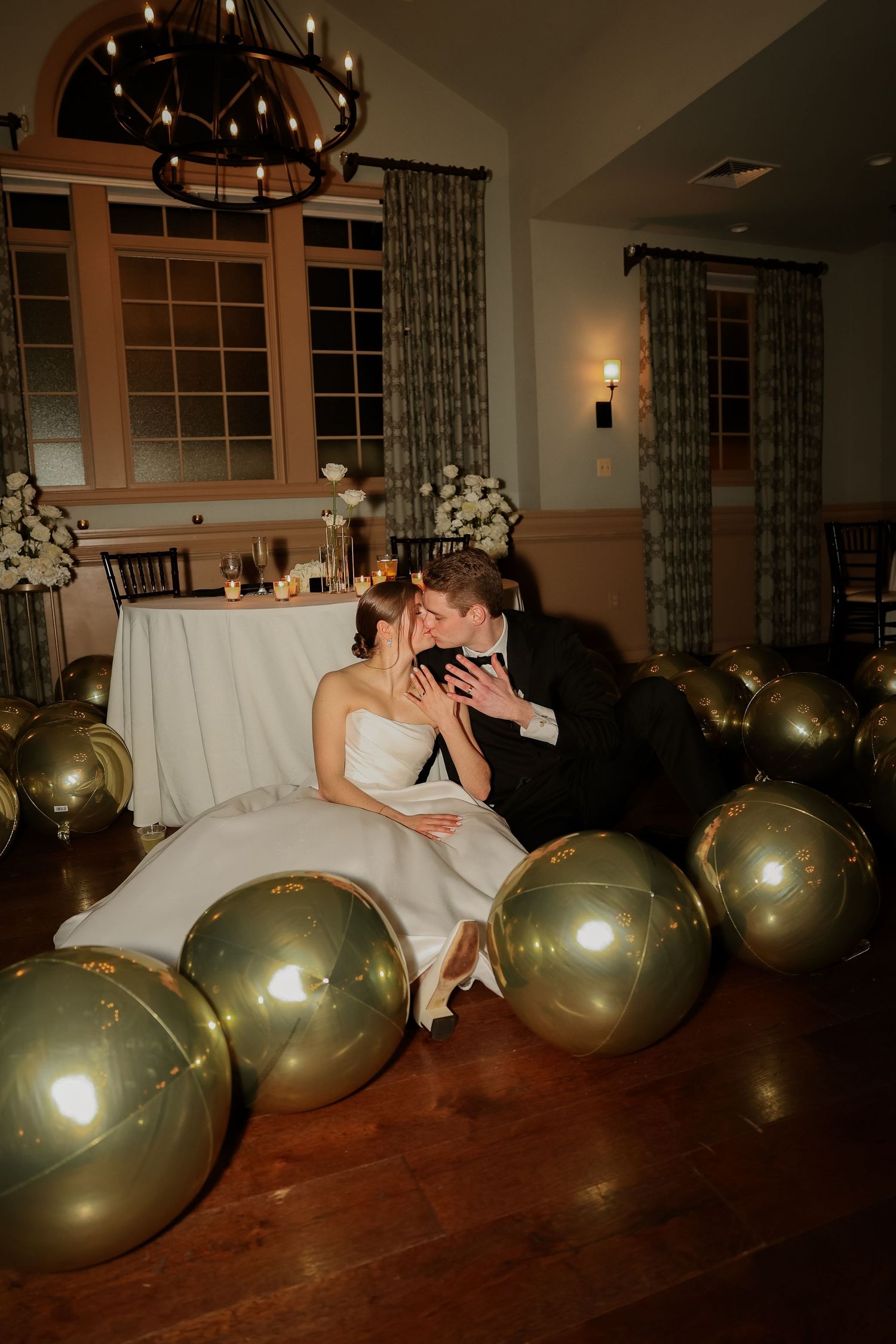 Party scene with large gold balloons decorating a dimly lit room.
