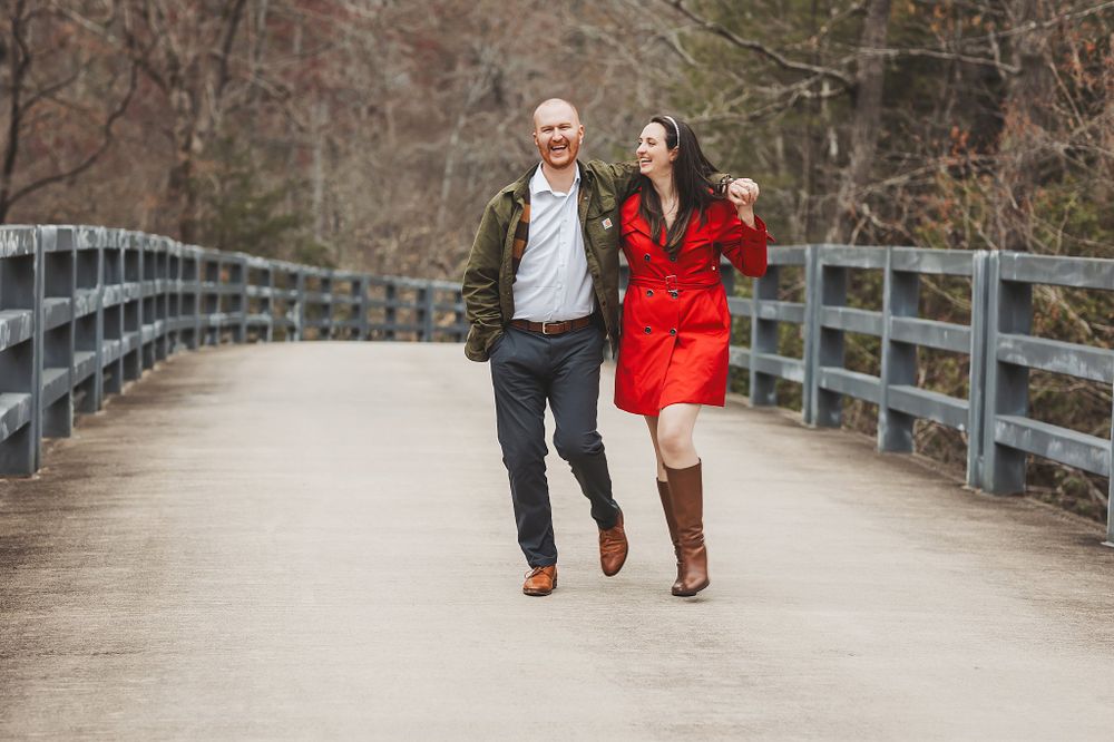 Long wooden boardwalk creates leading lines for romantic couple's portrait.