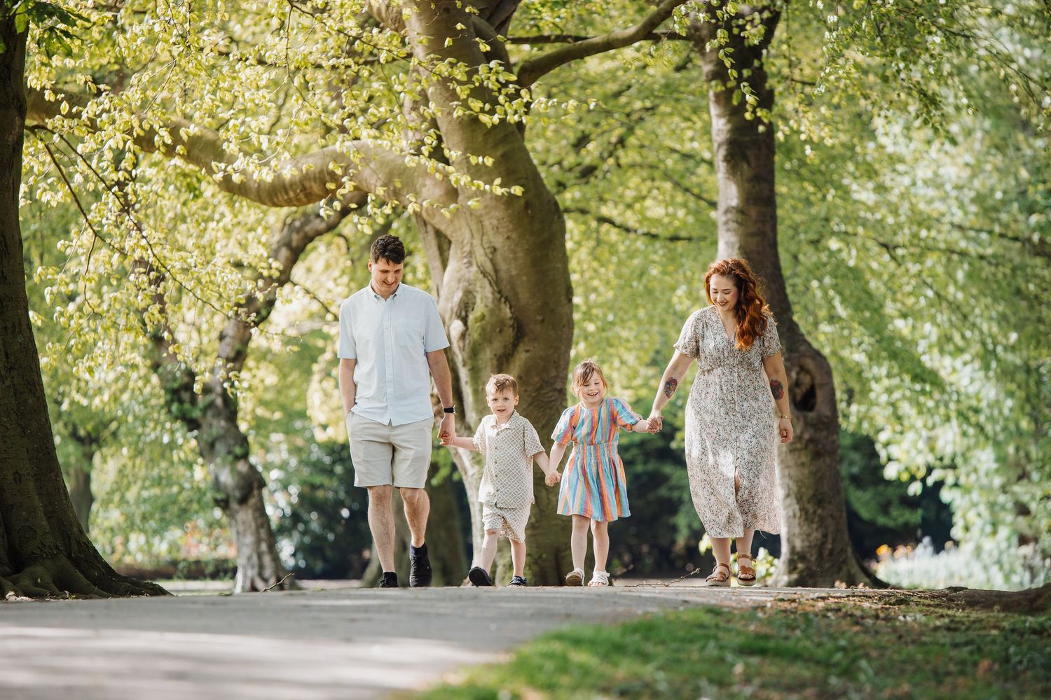 portrait of a family holding a new baby in an outdoor setting.