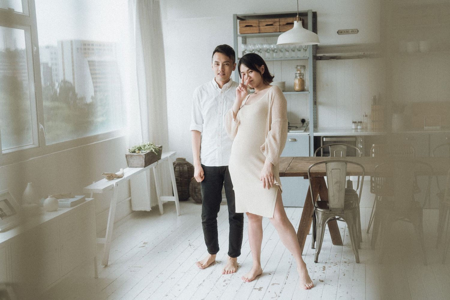 Clean minimalist pre-wedding photoshoot in bright white room with window light.