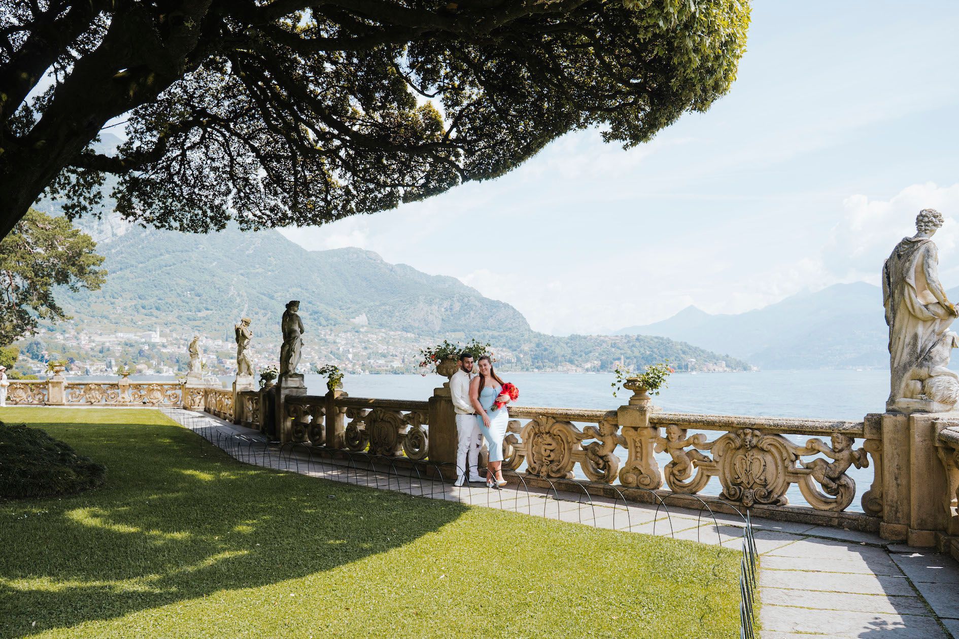 Scenic lakeside path with mountains in the background and benches for viewing the alpine landscape and water.
