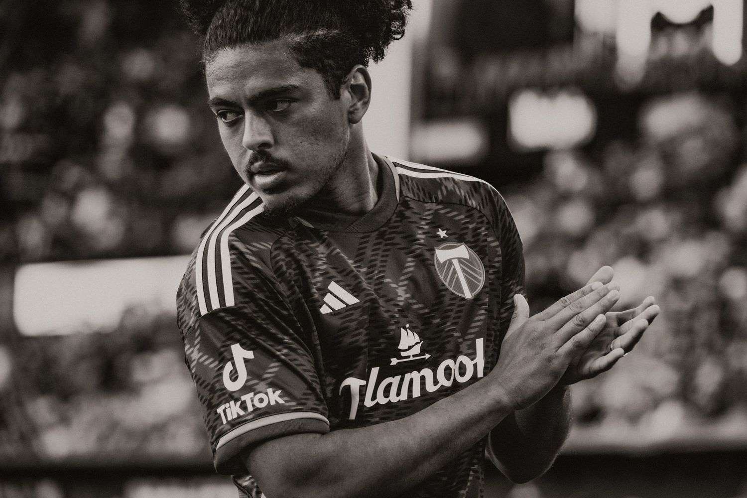 Black and white close-up of Portland Timbers soccer player in Adidas jersey during MLS match.