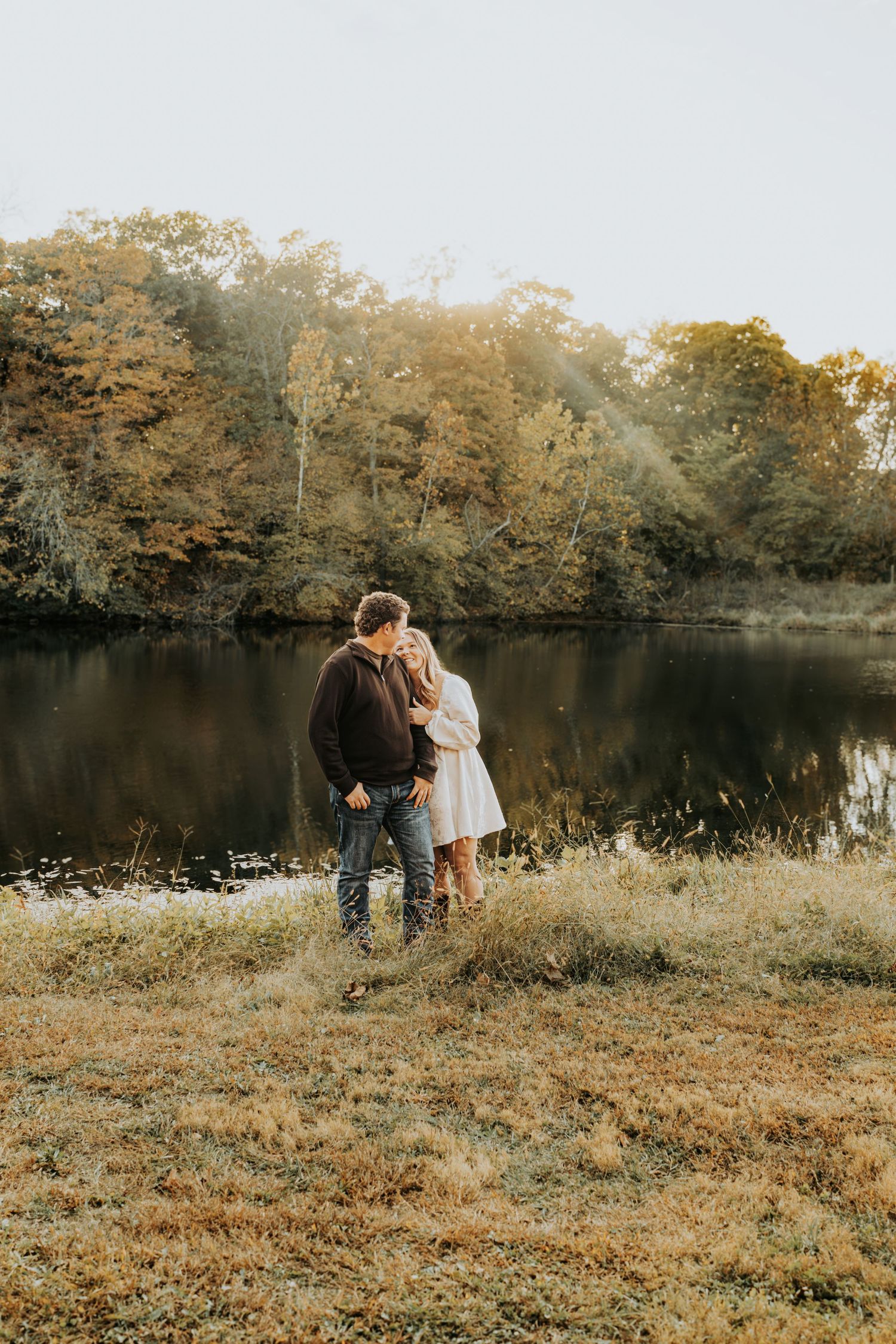 A joyful outdoor portrait session in golden sunlight among trees.