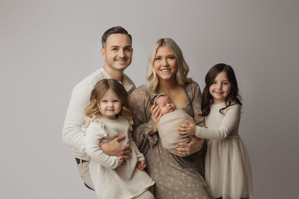 Family portrait series in neutral tones showing tender moments between parents and children in matching cream outfits.