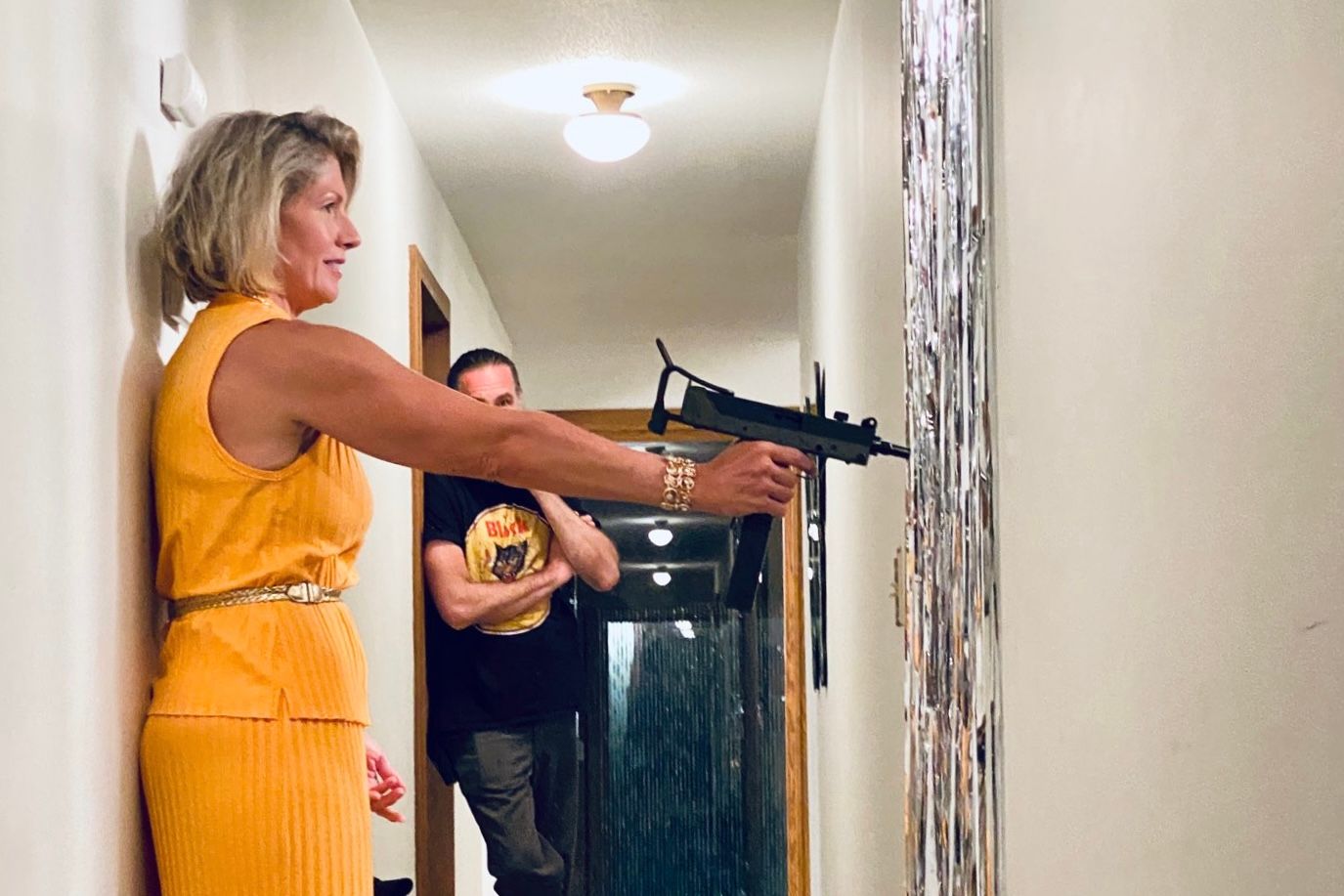 Film crew shooting a suspense scene in a hallway with actors in character.