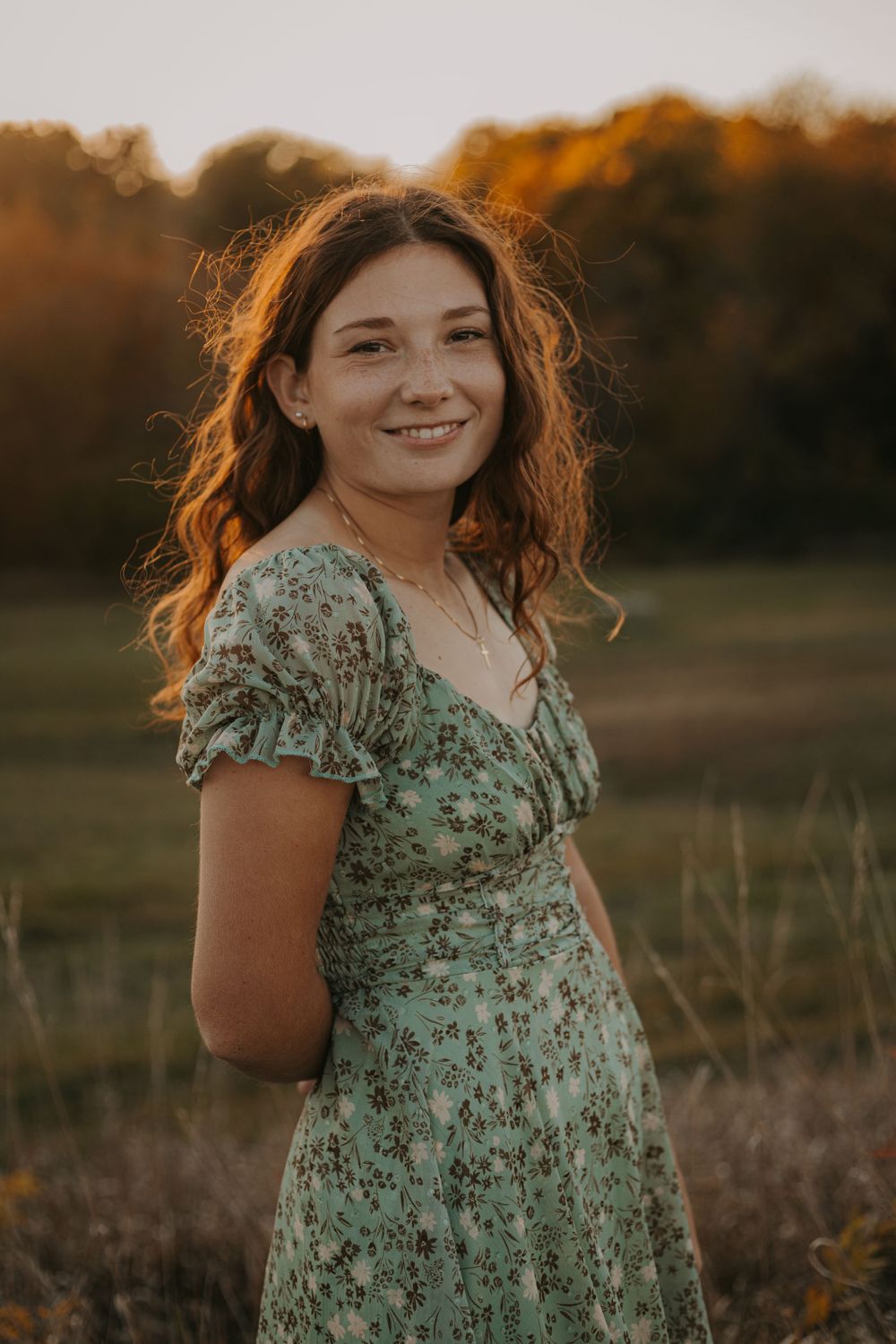 A floral mint dress glows in golden sunset light as soft breezes move through an autumn field.