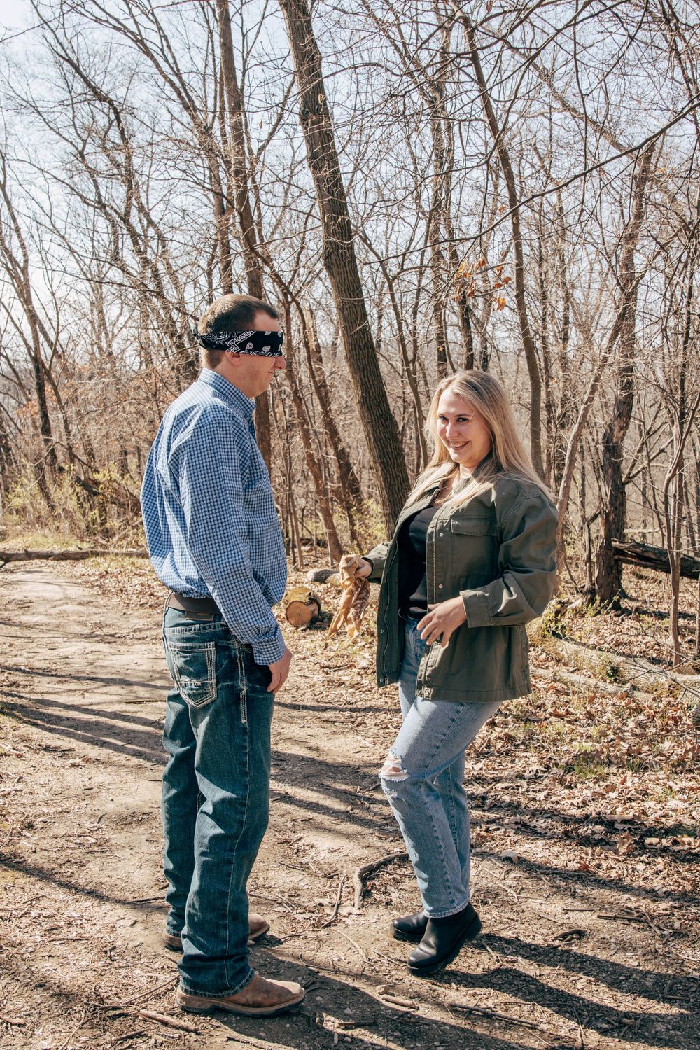 A casual outdoor conversation between two people on a sunny forest trail.