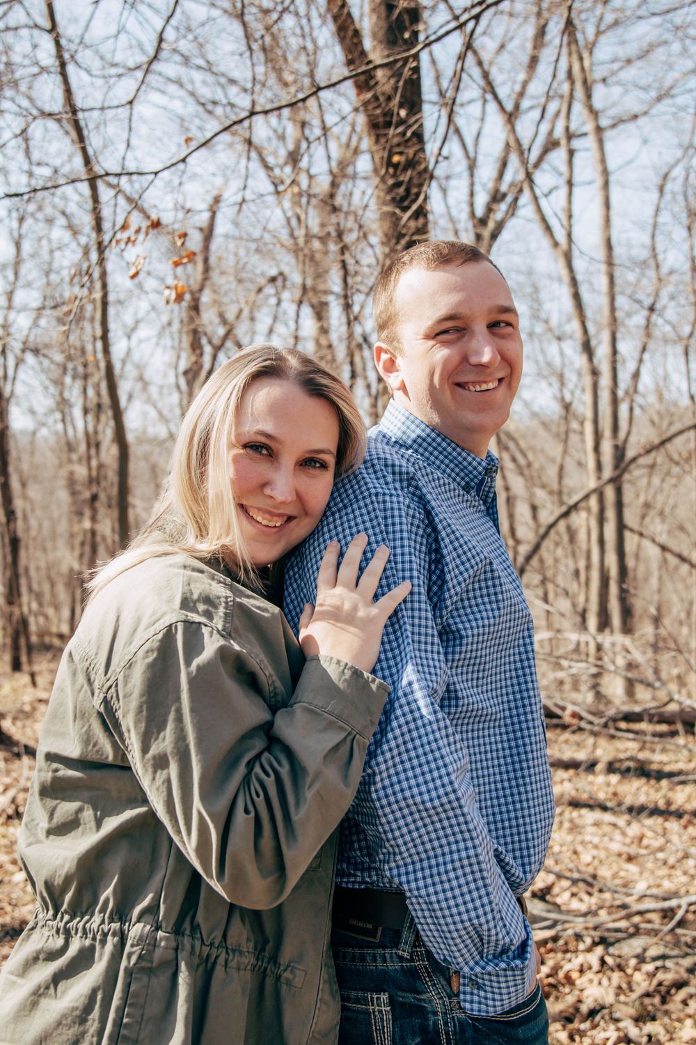 A happy couple sharing a playful moment while hiking in the woods.