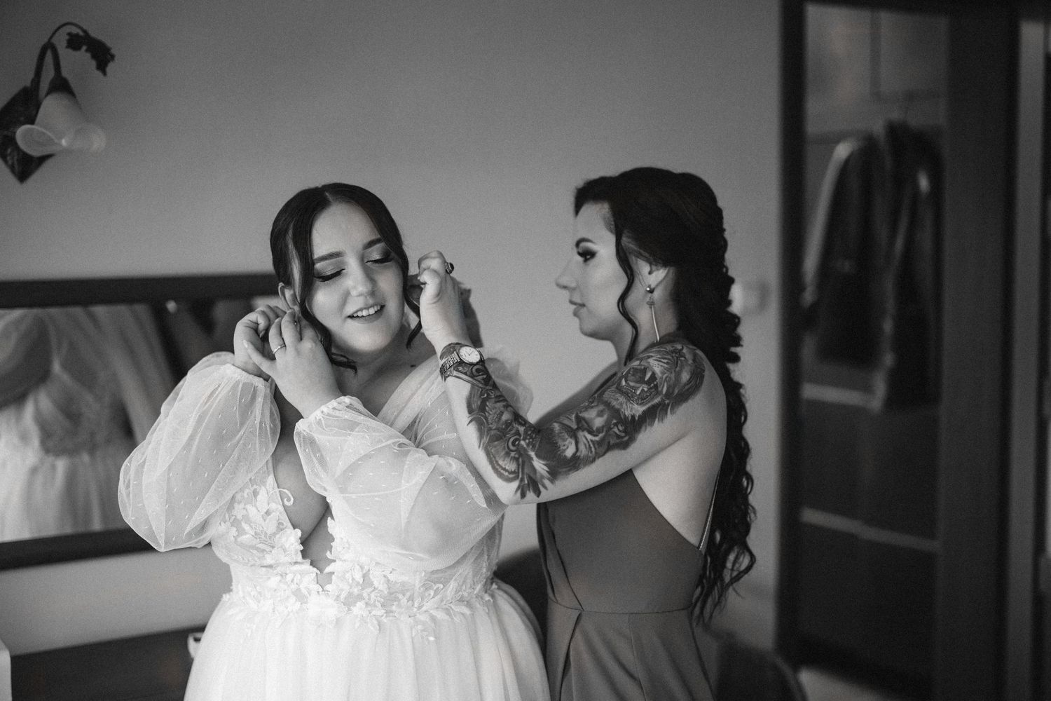 A black and white candid photo capturing joyful emotion while getting ready for a special occasion.