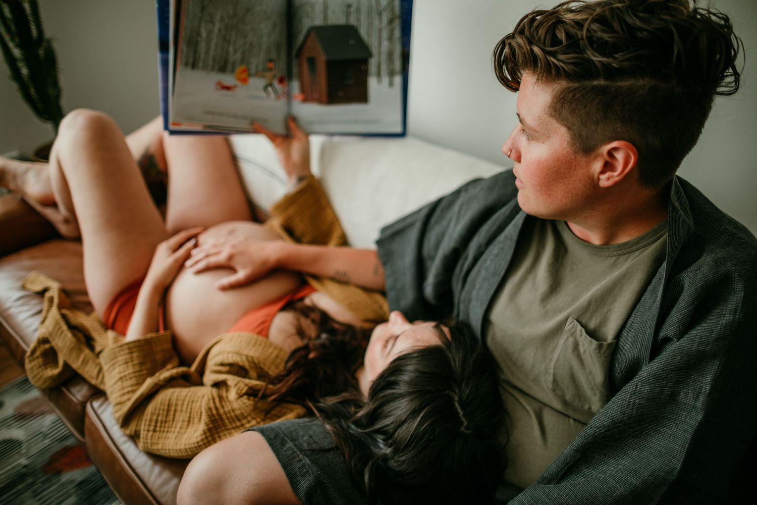 close up shot of couple reading book on couch portland oregon maternity photography rushes & waves