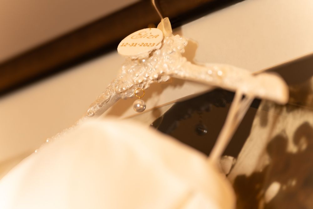 White soap suds and foam drip from a washing machine in a close-up sepia-toned photograph.
