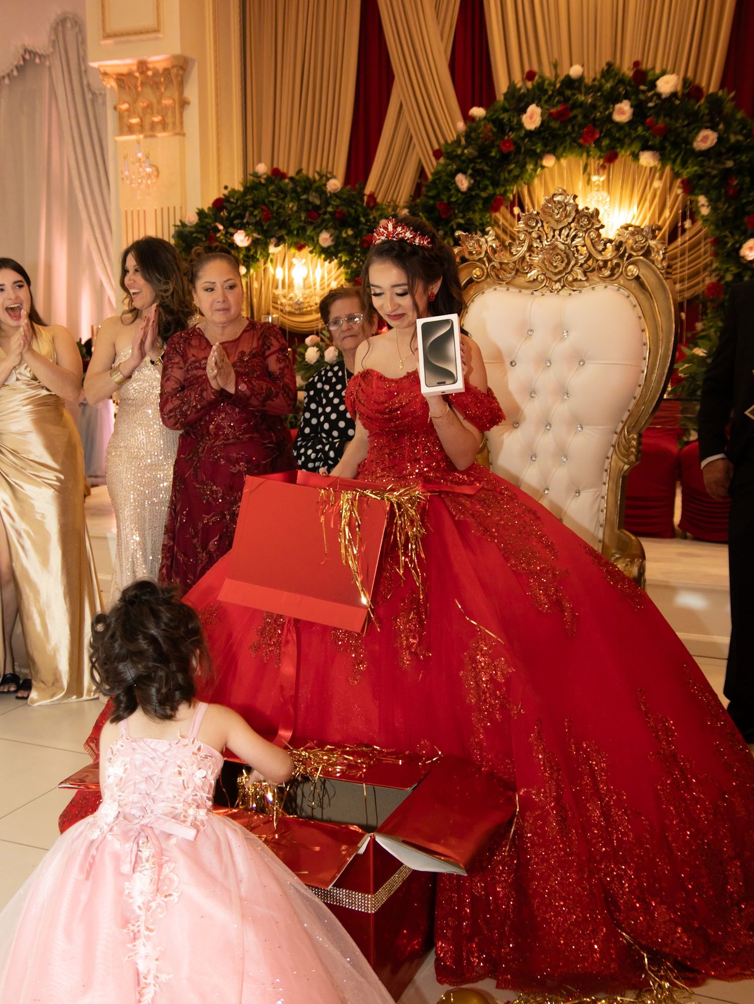 Ornate celebration in a grand ballroom with decorative throne and floral arch.