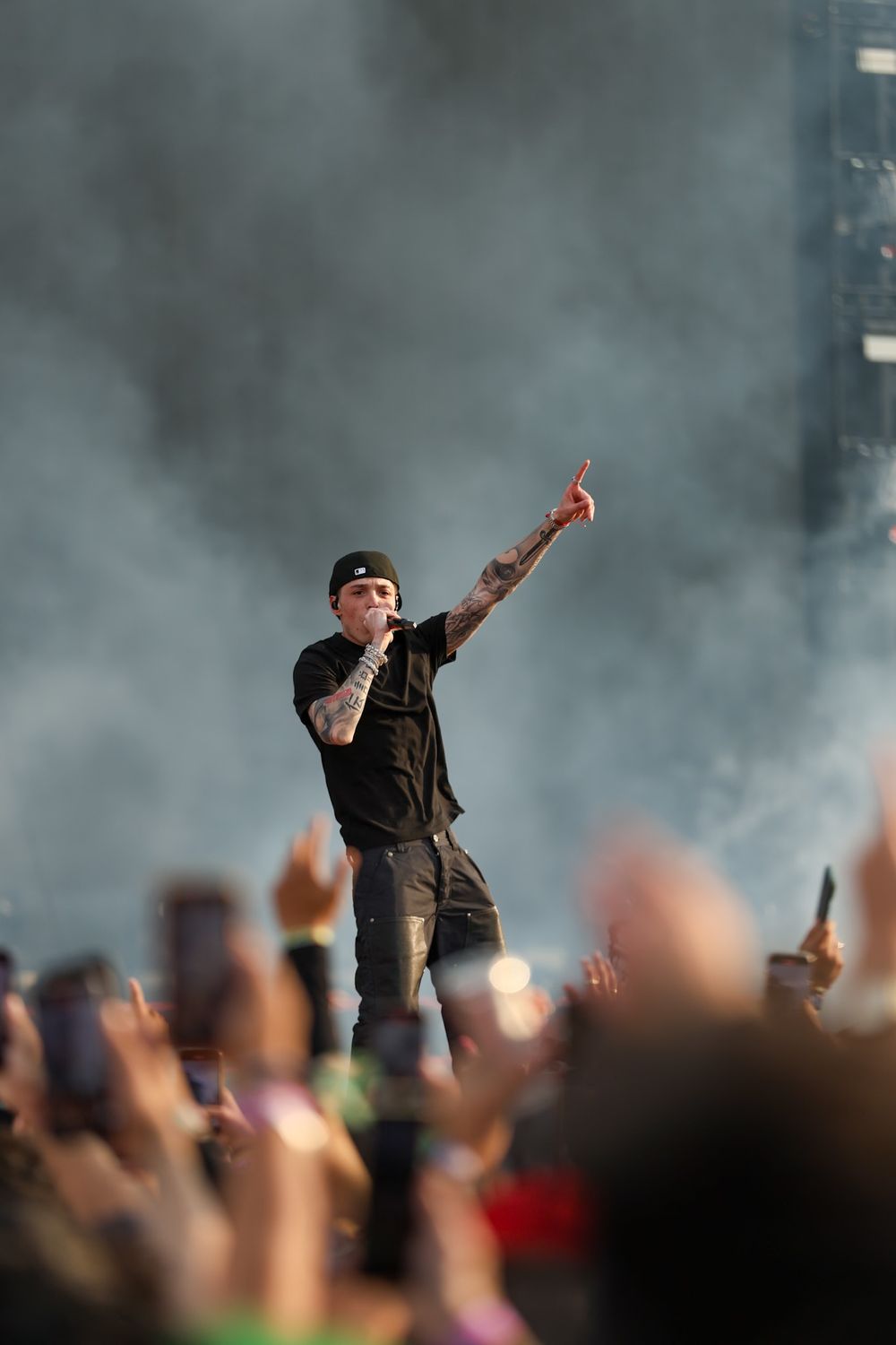 Concert performer silhouetted against smoky atmosphere with crowd below.