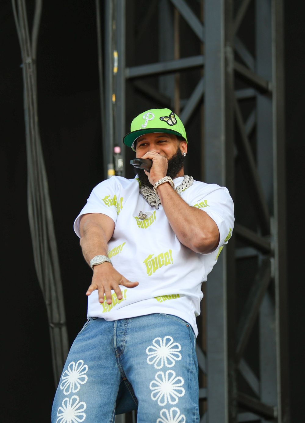 Artist in casual wear engaging audience during daytime outdoor performance.