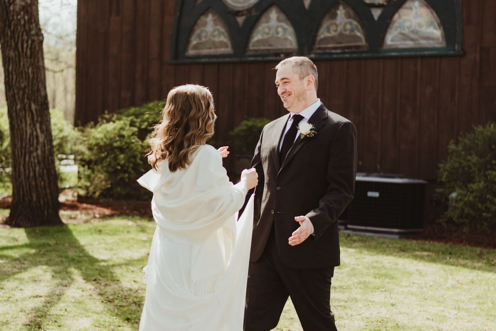 Wedding couple sharing a romantic moment outside rustic wooden chapel.