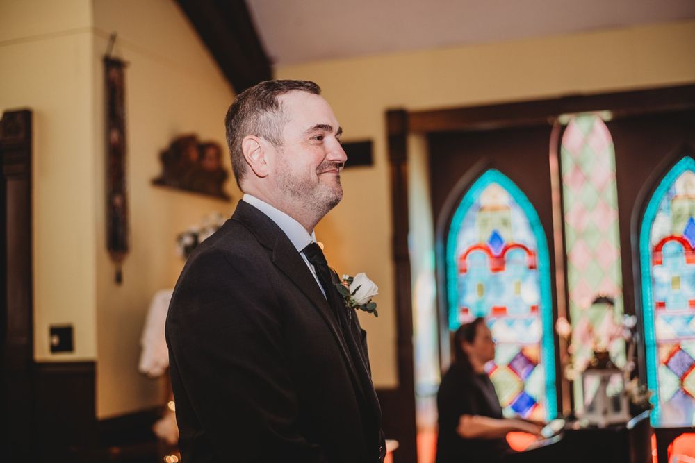 Church interior with stained glass windows during wedding ceremony.