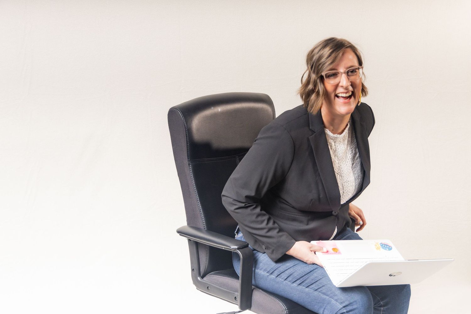 Professional in business attire sits casually in office chair while reviewing documents.