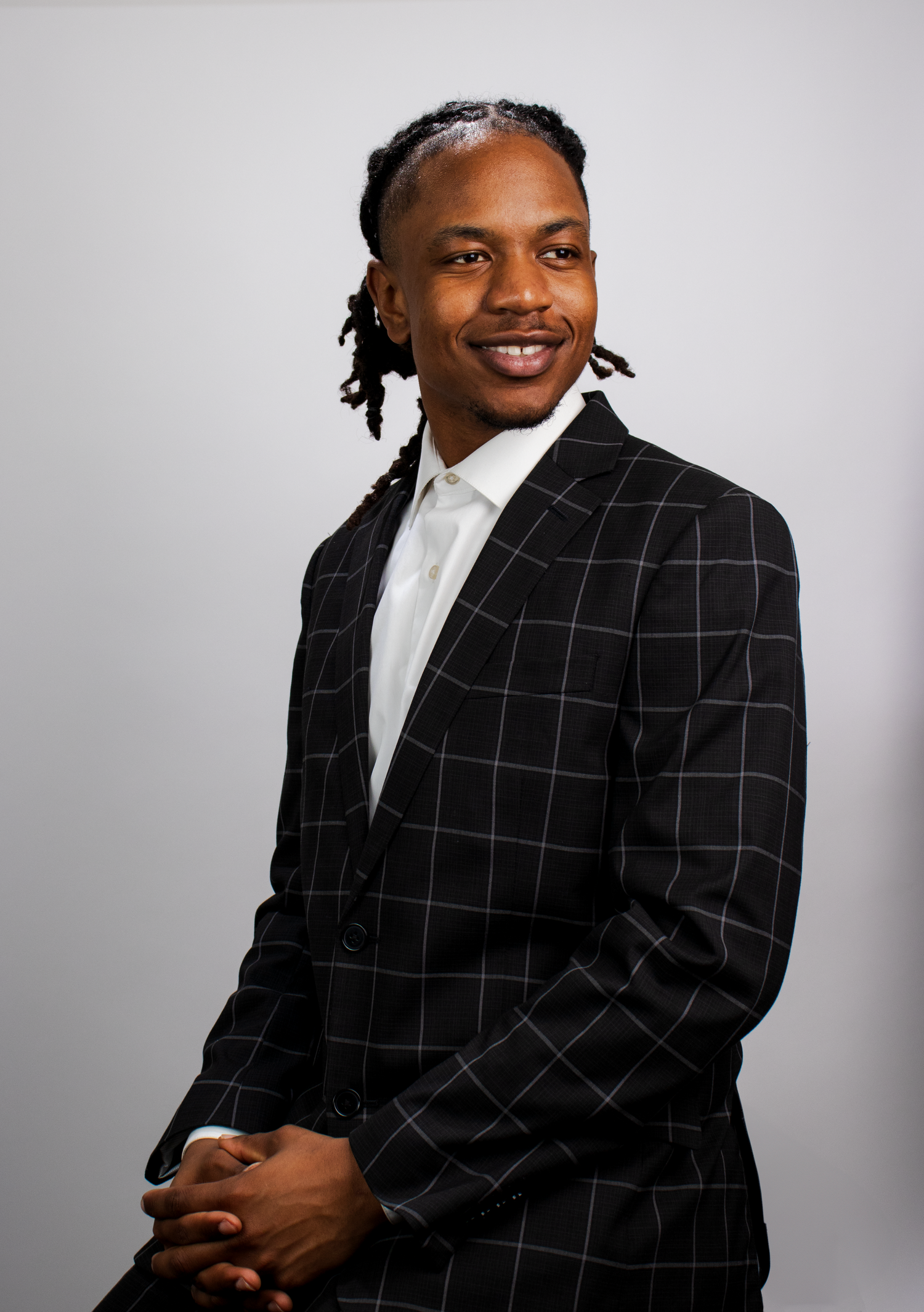 A professional portrait of a man in a checkered suit smiling confidently, showcasing corporate or editorial photography by Empax Studios.