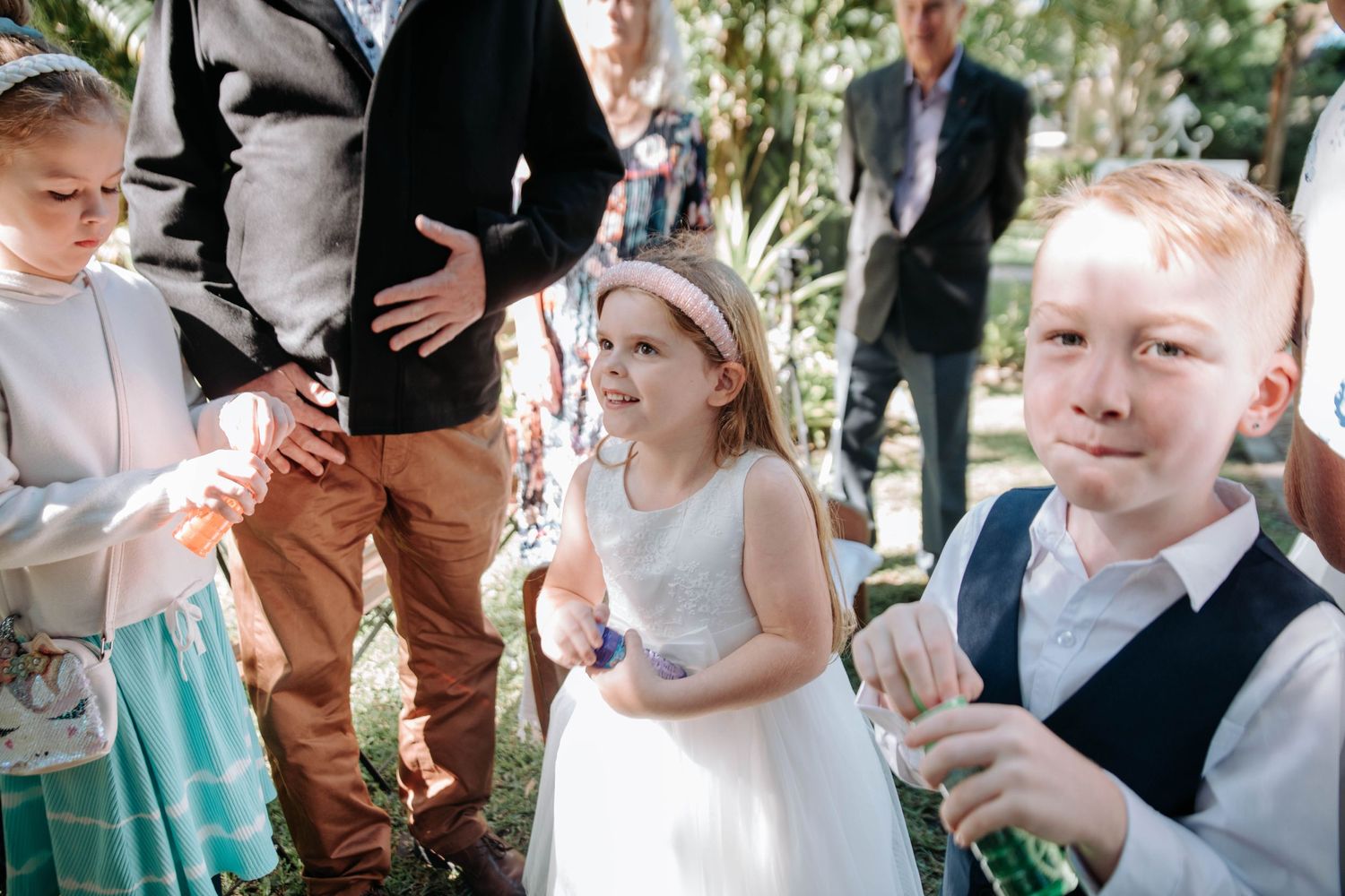 A group of children playing with bubbles at an outdoor garden event.