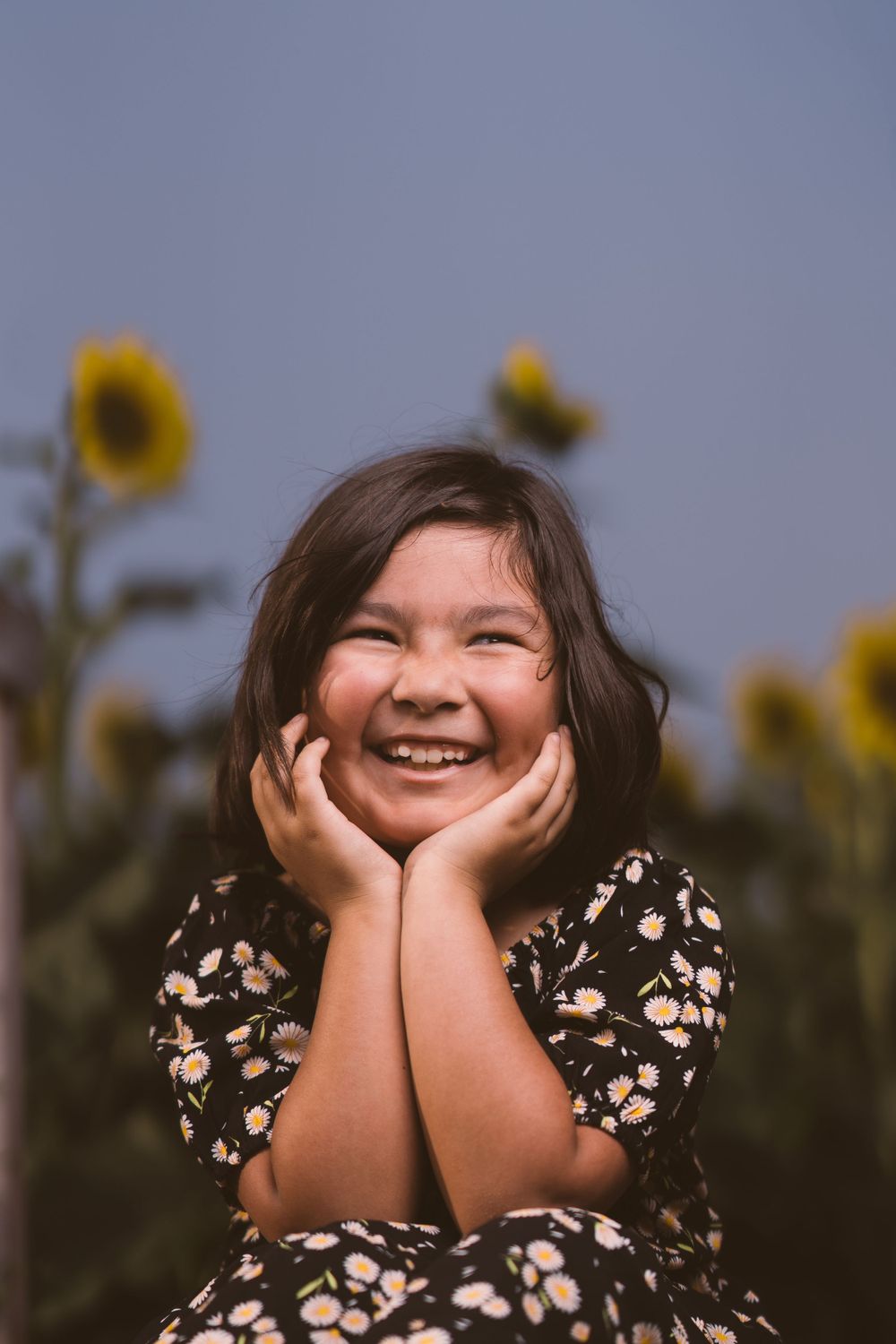 Joyful portrait series against sunflower backdrop showing genuine expressions of happiness.