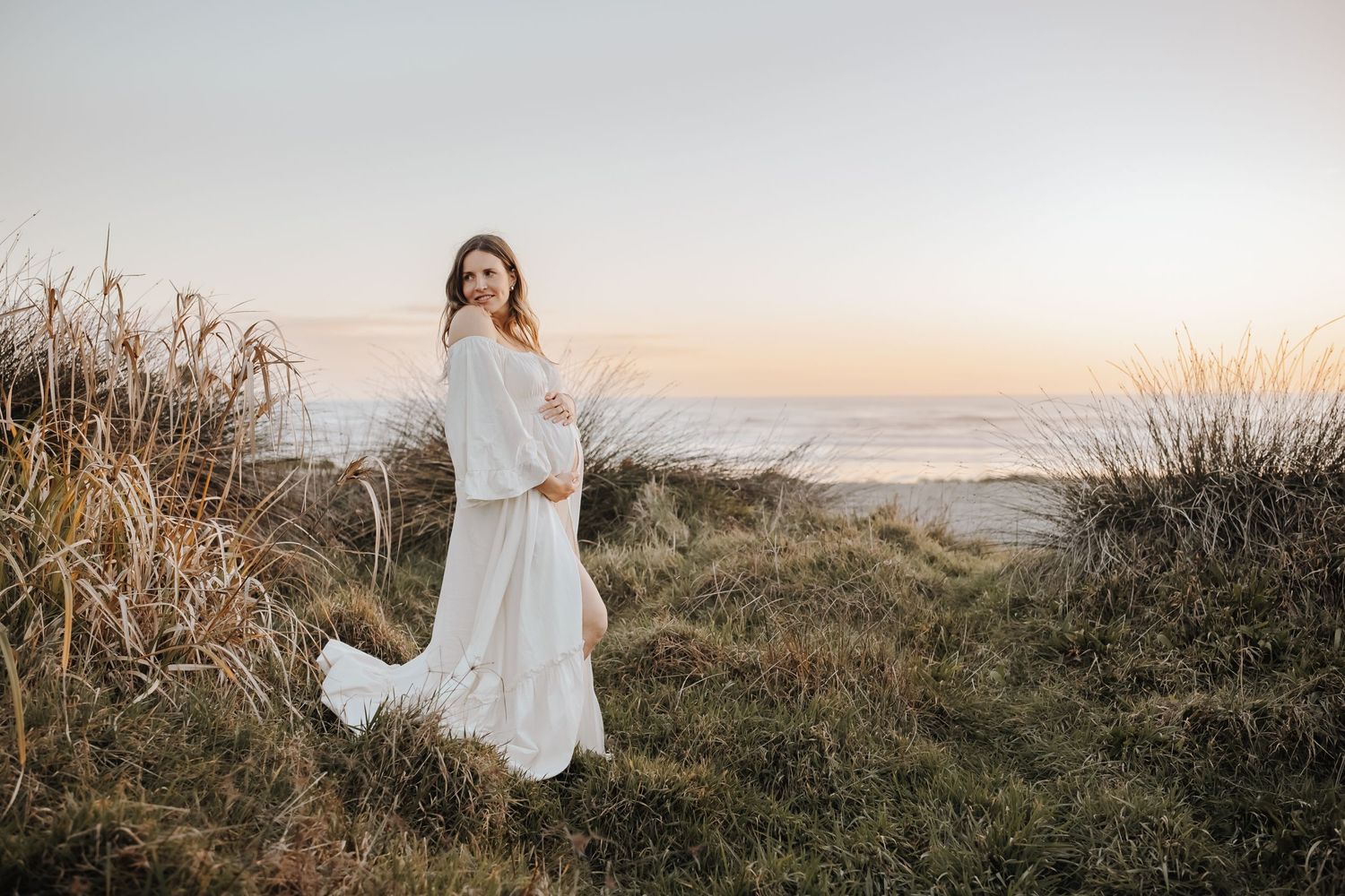 Maternity portrait of expectant mother on golden-hour beach Westport NZ